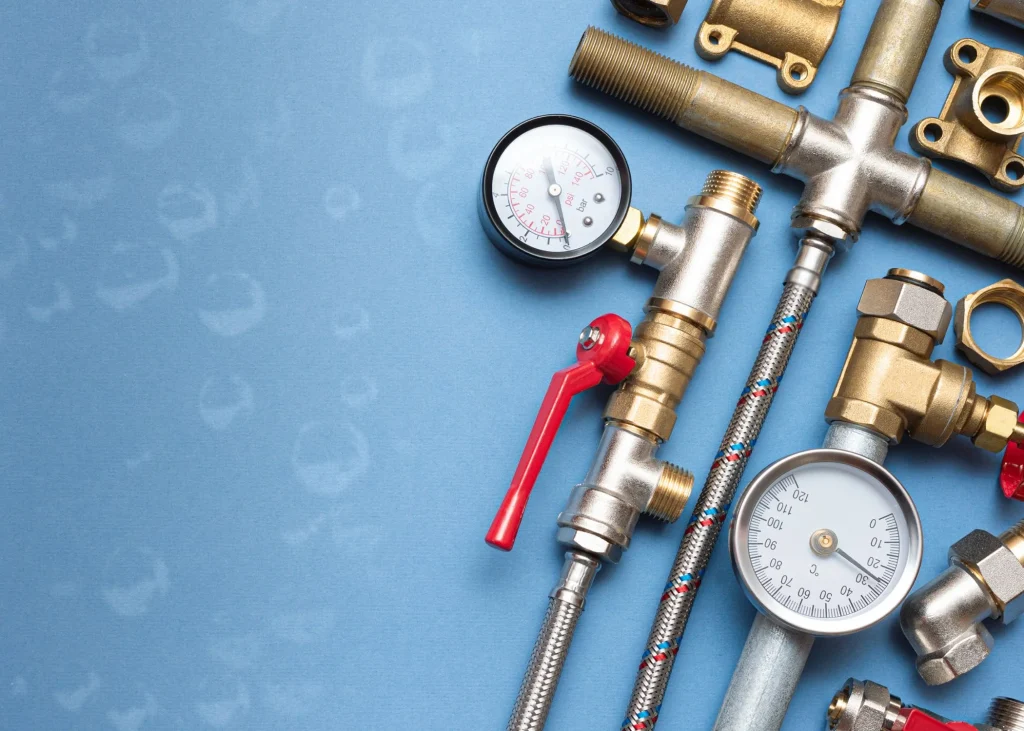 Plumbing tools and components including pressure gauges, valves, and pipes on a blue background, representing professional plumbing services in Bucks County.